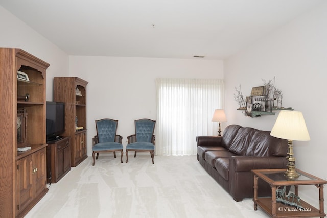 living area featuring visible vents and light colored carpet