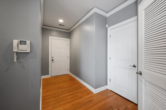 corridor featuring crown molding and light hardwood / wood-style floors