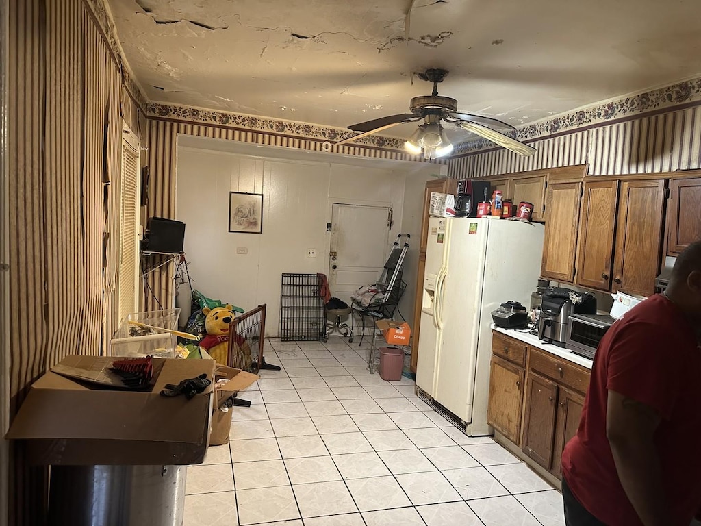 kitchen with light tile patterned floors, white refrigerator with ice dispenser, and ceiling fan