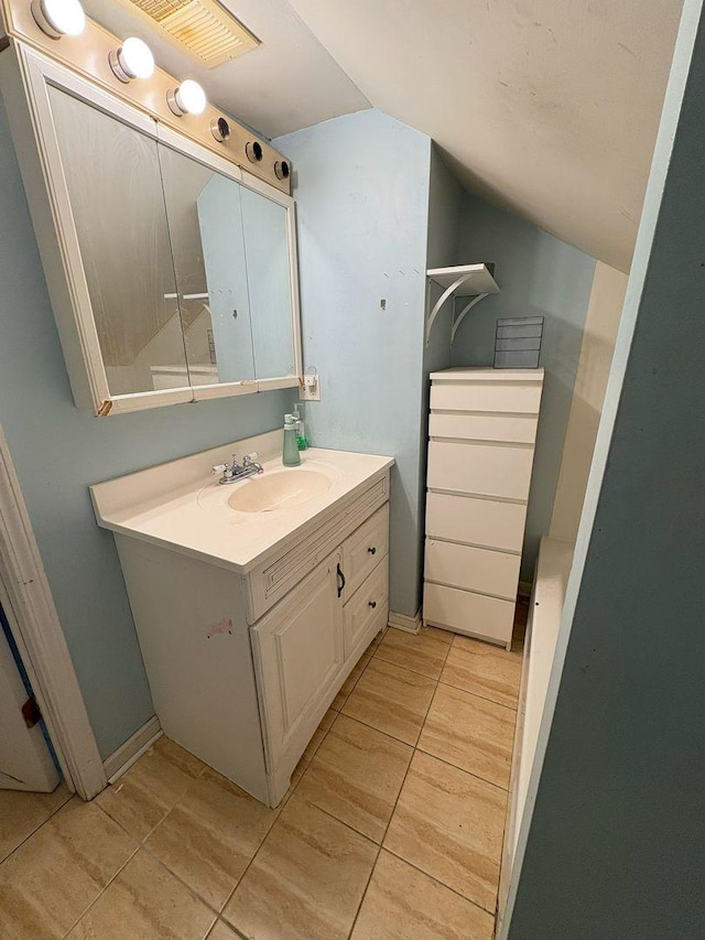 bathroom featuring vanity and lofted ceiling