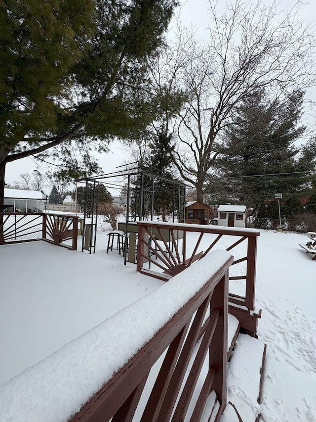 yard covered in snow featuring a storage shed