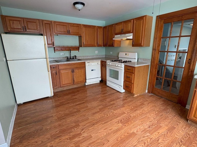 kitchen featuring sink, white appliances, and light hardwood / wood-style flooring