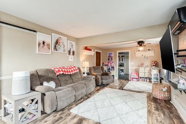 living room featuring hardwood / wood-style floors and ceiling fan