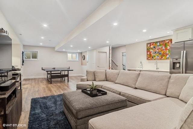 living room featuring sink and light hardwood / wood-style flooring