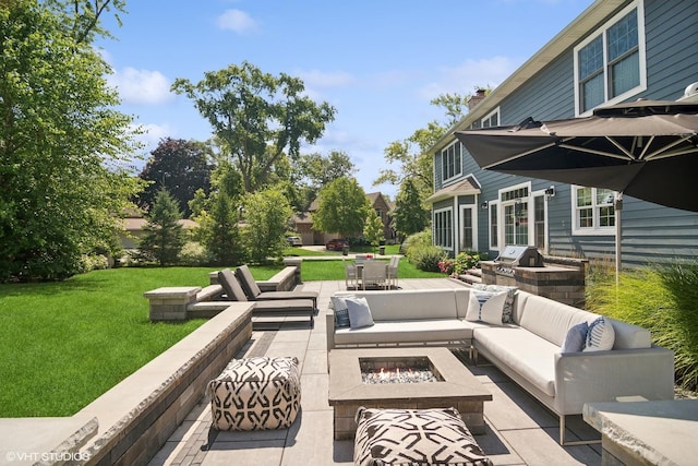 view of patio / terrace featuring an outdoor living space with a fire pit and exterior kitchen