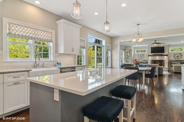 kitchen with white cabinetry, decorative light fixtures, and a kitchen island