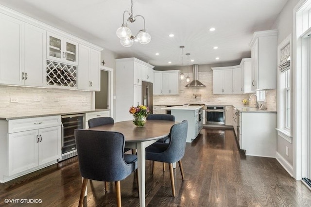 dining room featuring wine cooler, dark hardwood / wood-style floors, and indoor wet bar