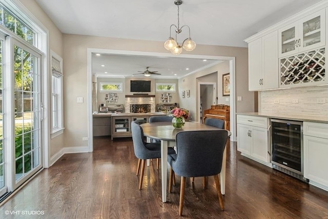 dining room with wine cooler, indoor bar, plenty of natural light, and dark wood-type flooring