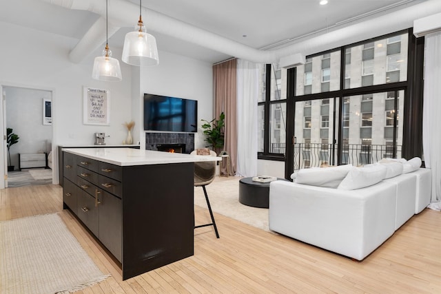 kitchen featuring hanging light fixtures, a kitchen bar, and light hardwood / wood-style flooring