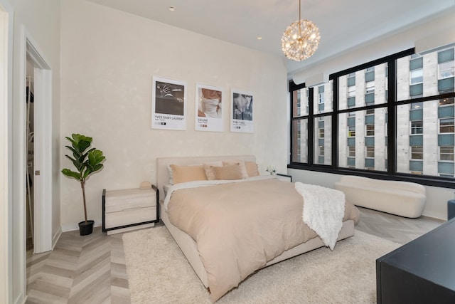 bedroom featuring parquet flooring and a chandelier