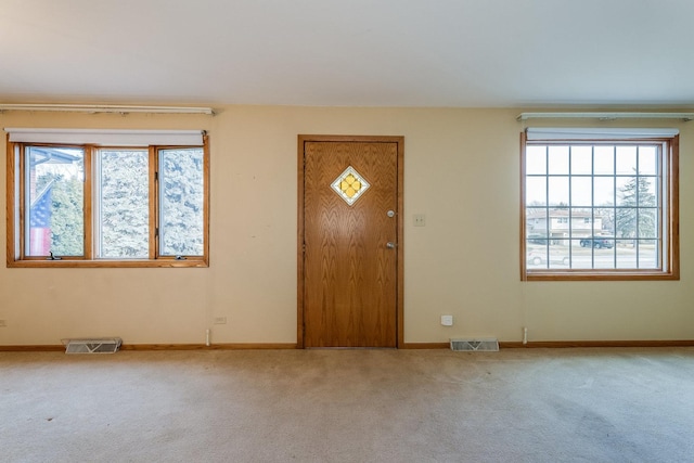 foyer entrance featuring light colored carpet