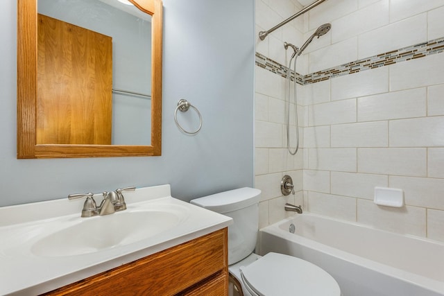 full bathroom featuring vanity, tiled shower / bath combo, and toilet