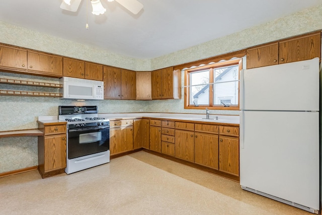 kitchen with sink, white appliances, and ceiling fan