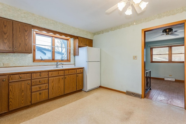 kitchen with white refrigerator, ceiling fan, and sink