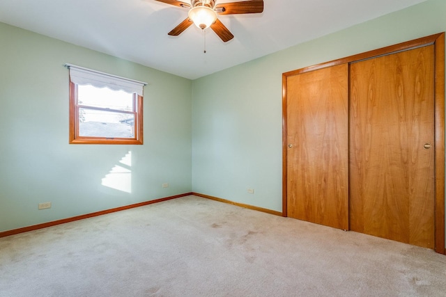 unfurnished bedroom featuring carpet floors, a closet, and ceiling fan