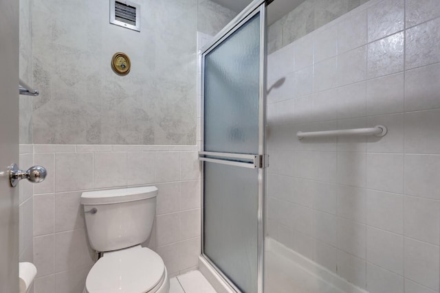 2 Oak Brook Club Dr Unit B209, Oak Brook, IL 60523 - bathroom with toilet, visible vents, a shower stall, and tile walls