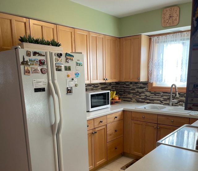 kitchen featuring sink, range, light tile patterned floors, white fridge, and decorative backsplash