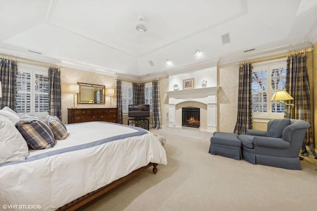 carpeted bedroom featuring ornamental molding, a fireplace, and a raised ceiling