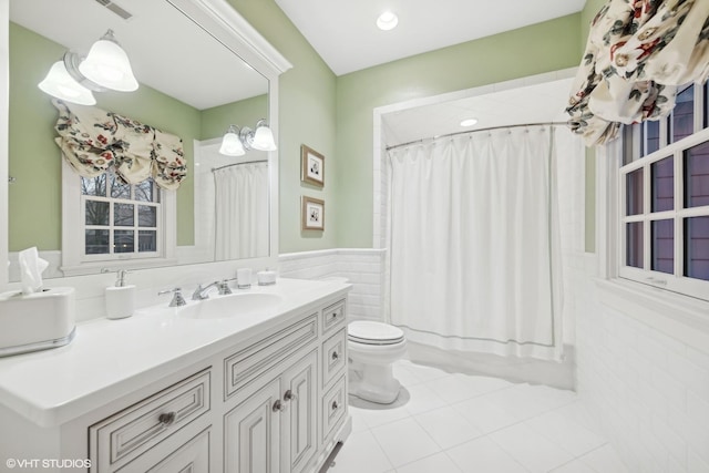 full bathroom with tile walls, tile patterned flooring, vanity, toilet, and shower / bath combo with shower curtain