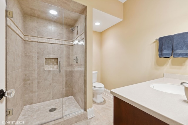 bathroom featuring vanity, a shower with shower door, tile patterned floors, and toilet