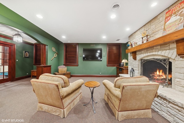 living room featuring light carpet and a fireplace