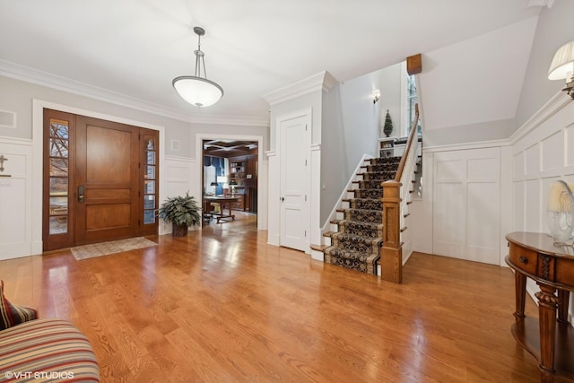 foyer entrance featuring crown molding and light hardwood / wood-style floors