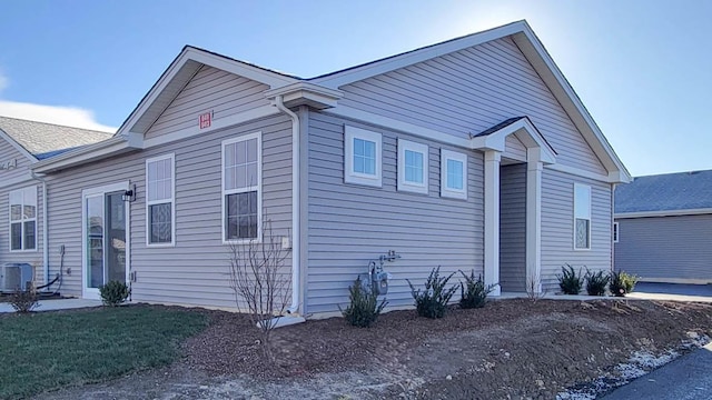 view of property exterior featuring central AC and a lawn