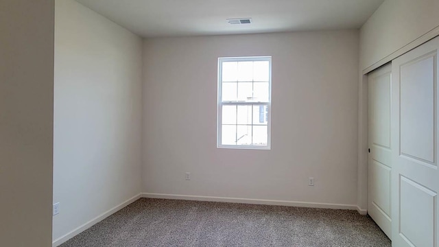 unfurnished bedroom featuring carpet flooring and a closet