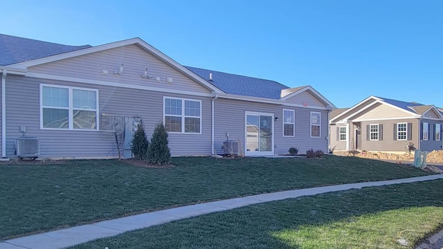 view of front of home with central AC and a front lawn