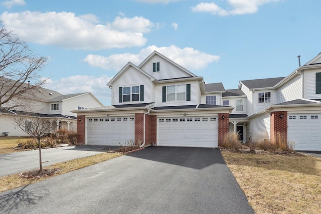 view of front facade with a garage, brick siding, and driveway