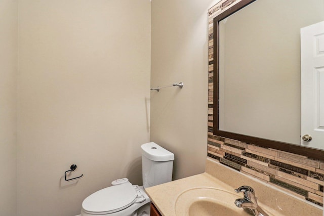 bathroom featuring backsplash, toilet, and vanity