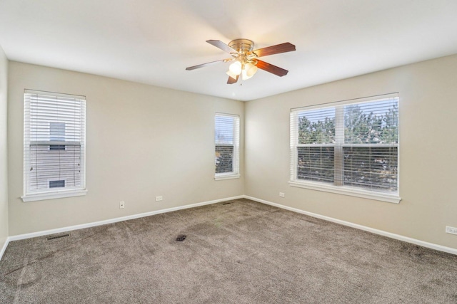 spare room featuring visible vents, baseboards, carpet, and a ceiling fan