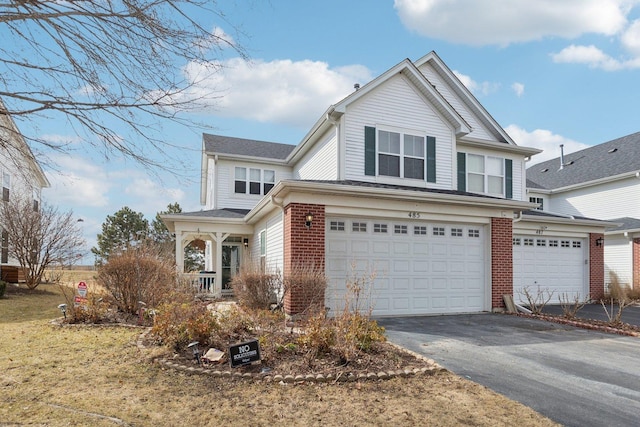 view of front facade featuring a garage, brick siding, and driveway