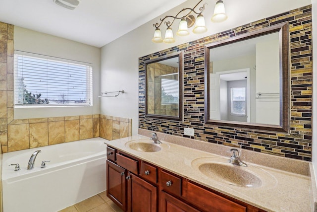 bathroom with tile patterned floors, tasteful backsplash, a garden tub, and a sink