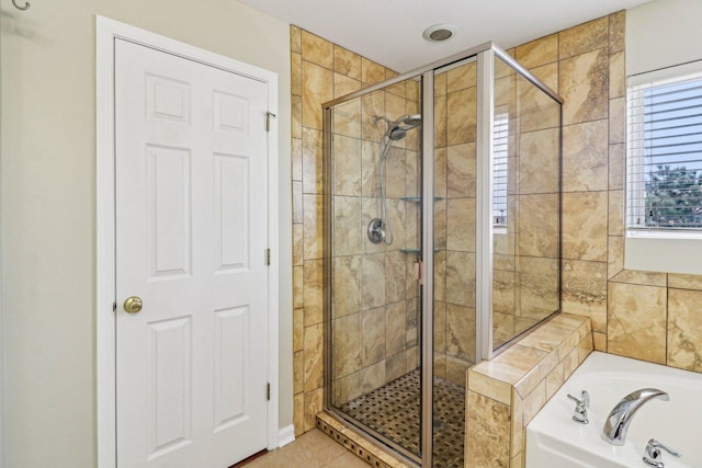 full bathroom featuring a stall shower, tile patterned flooring, and a bath