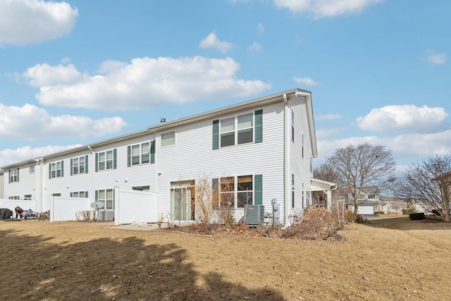 rear view of house featuring a yard and central AC