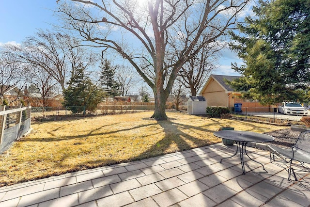 view of yard featuring fence private yard, a patio, and an outdoor structure