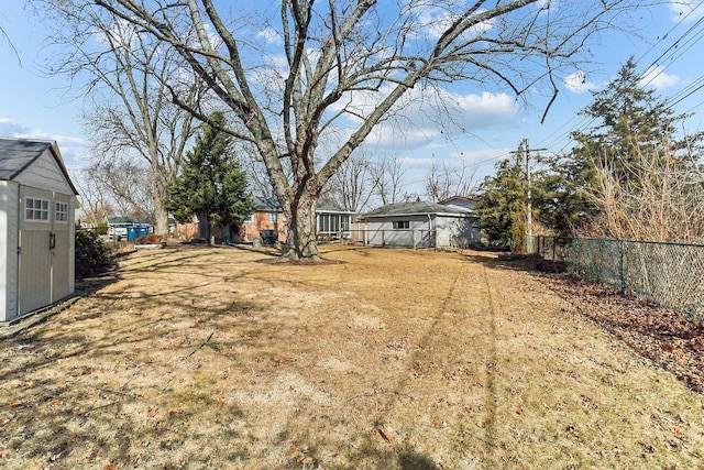 view of yard featuring a shed, fence, and an outdoor structure