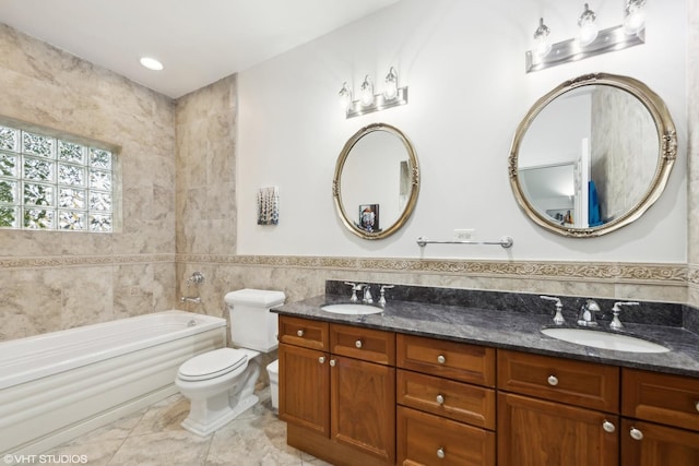 bathroom with toilet, tile walls, a tub, and vanity