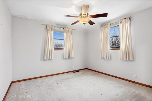 empty room featuring ceiling fan, plenty of natural light, and carpet flooring