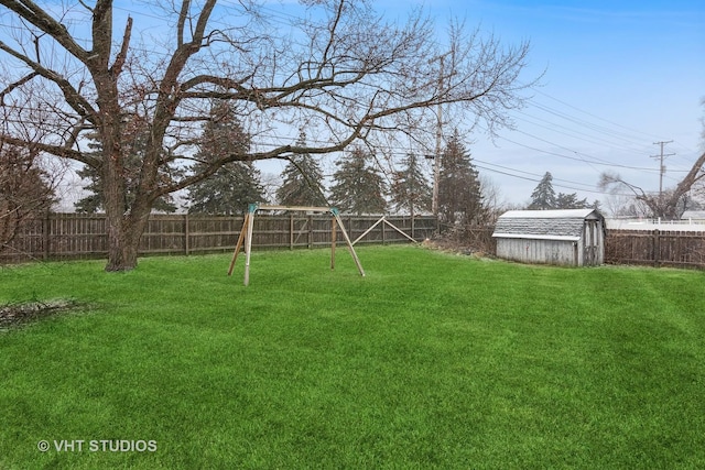 view of yard with a storage shed and a playground