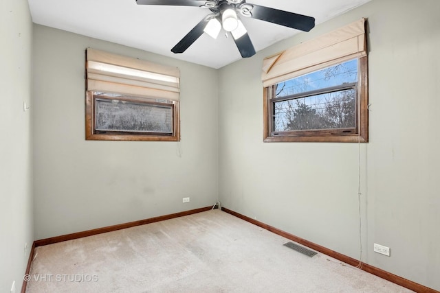 carpeted spare room with ceiling fan