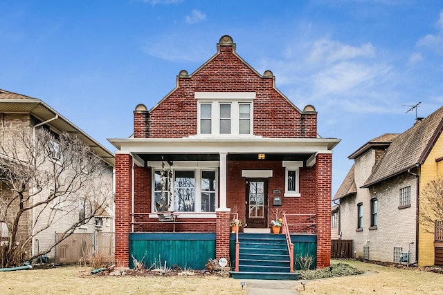 view of front of house with a porch and brick siding