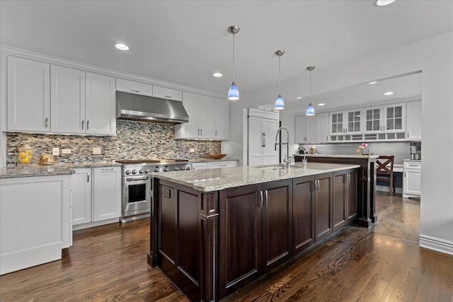 kitchen with white cabinetry, sink, hanging light fixtures, double oven range, and wall chimney exhaust hood