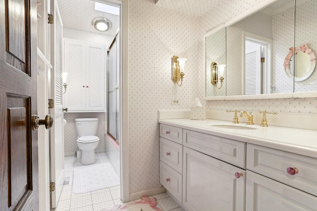 full bathroom with toilet, vanity, bath / shower combo with glass door, and tile patterned flooring