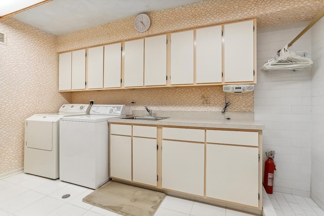 laundry room featuring independent washer and dryer, sink, and cabinets