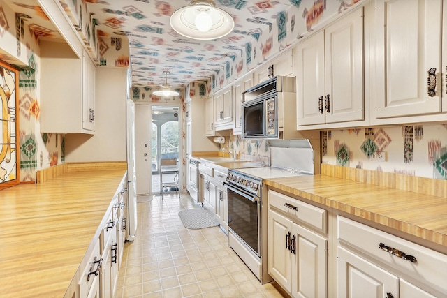 kitchen featuring electric stove and white cabinetry