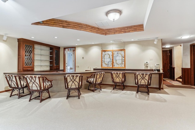 bar with light carpet and a tray ceiling