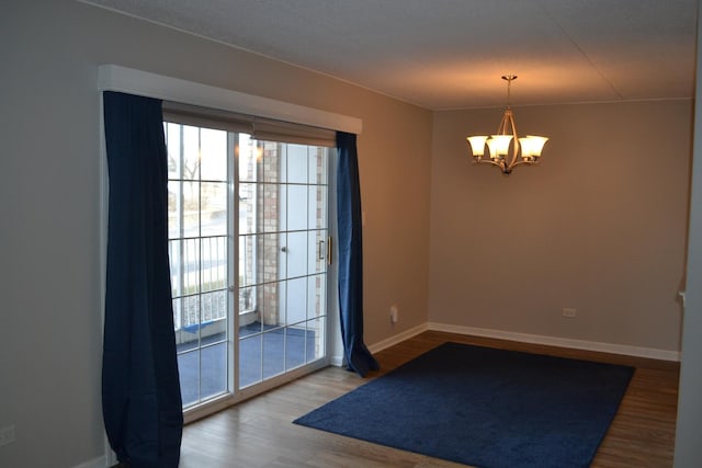 doorway featuring a notable chandelier and hardwood / wood-style flooring