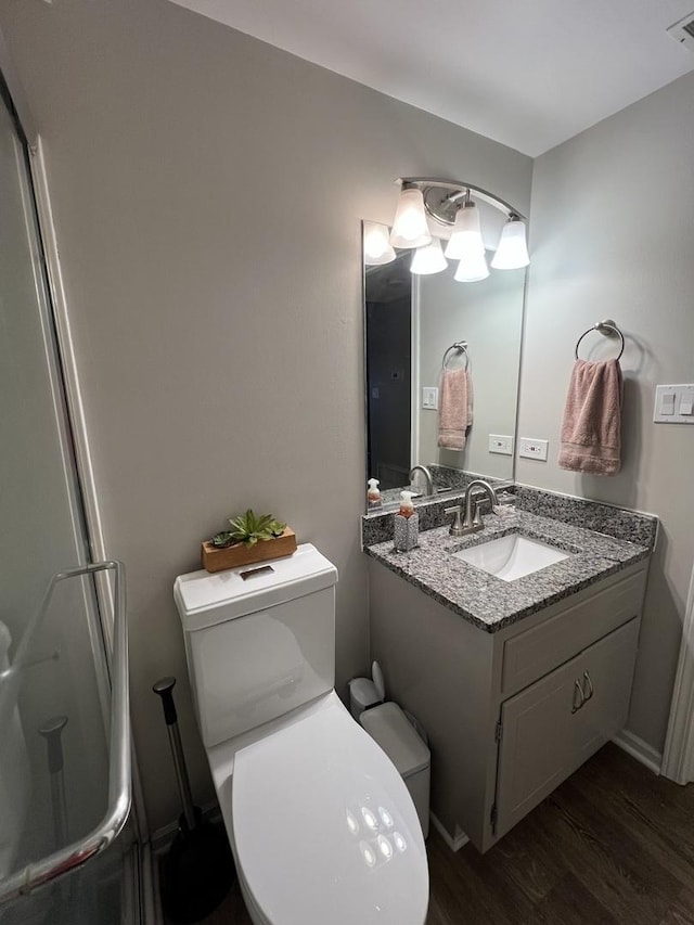 bathroom with wood-type flooring, vanity, and toilet